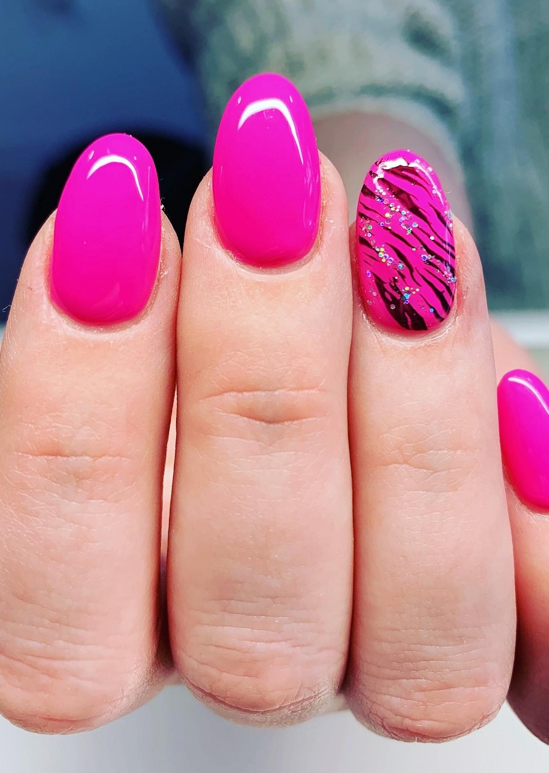 Felroze amandelvormige nagels met een accentnagel in zwarte zebraprint